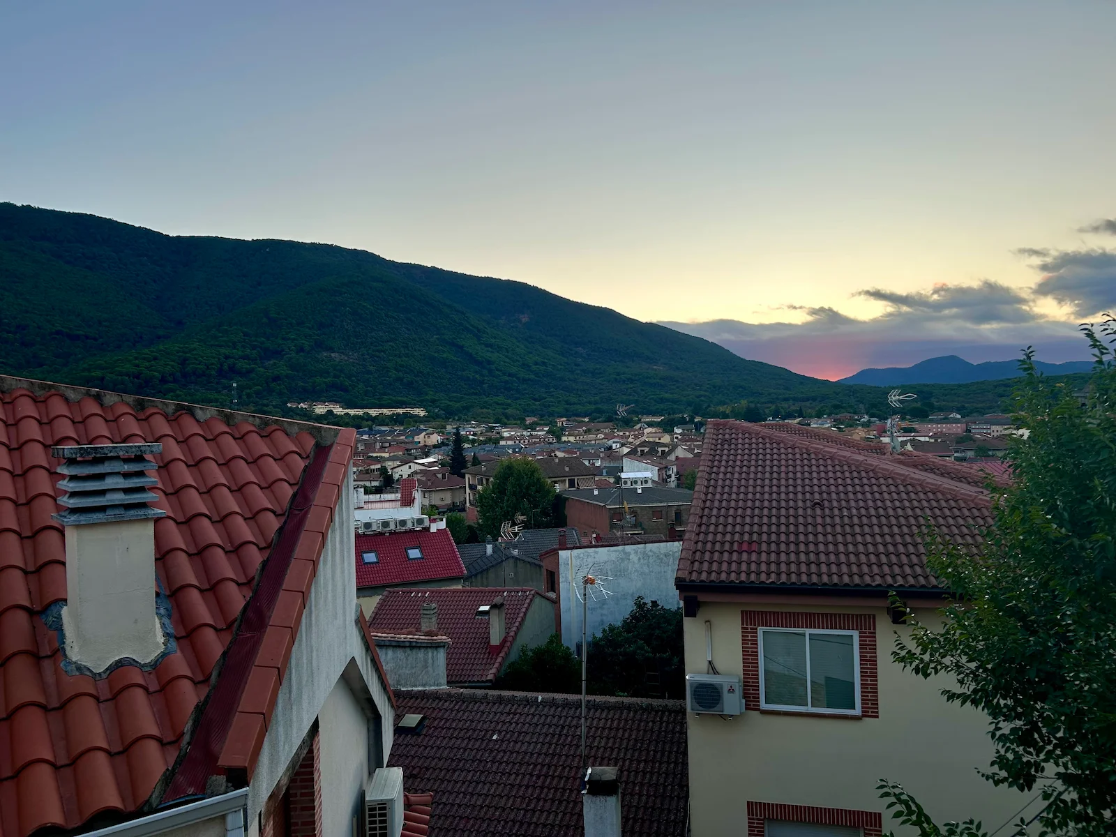 Un despertar, salir al balcón y ver salir el sol a lo lejos en medio de dos montañas