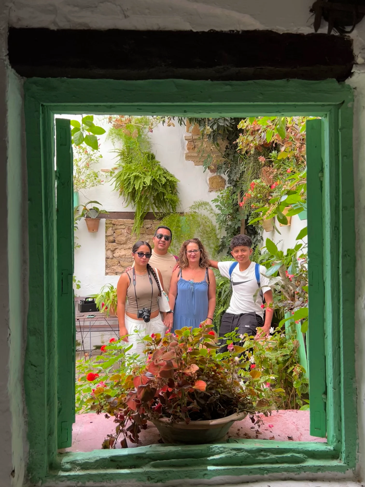Ventana rodeada de plantas en Córdoba, reflejando una familia disfrutando del viaje