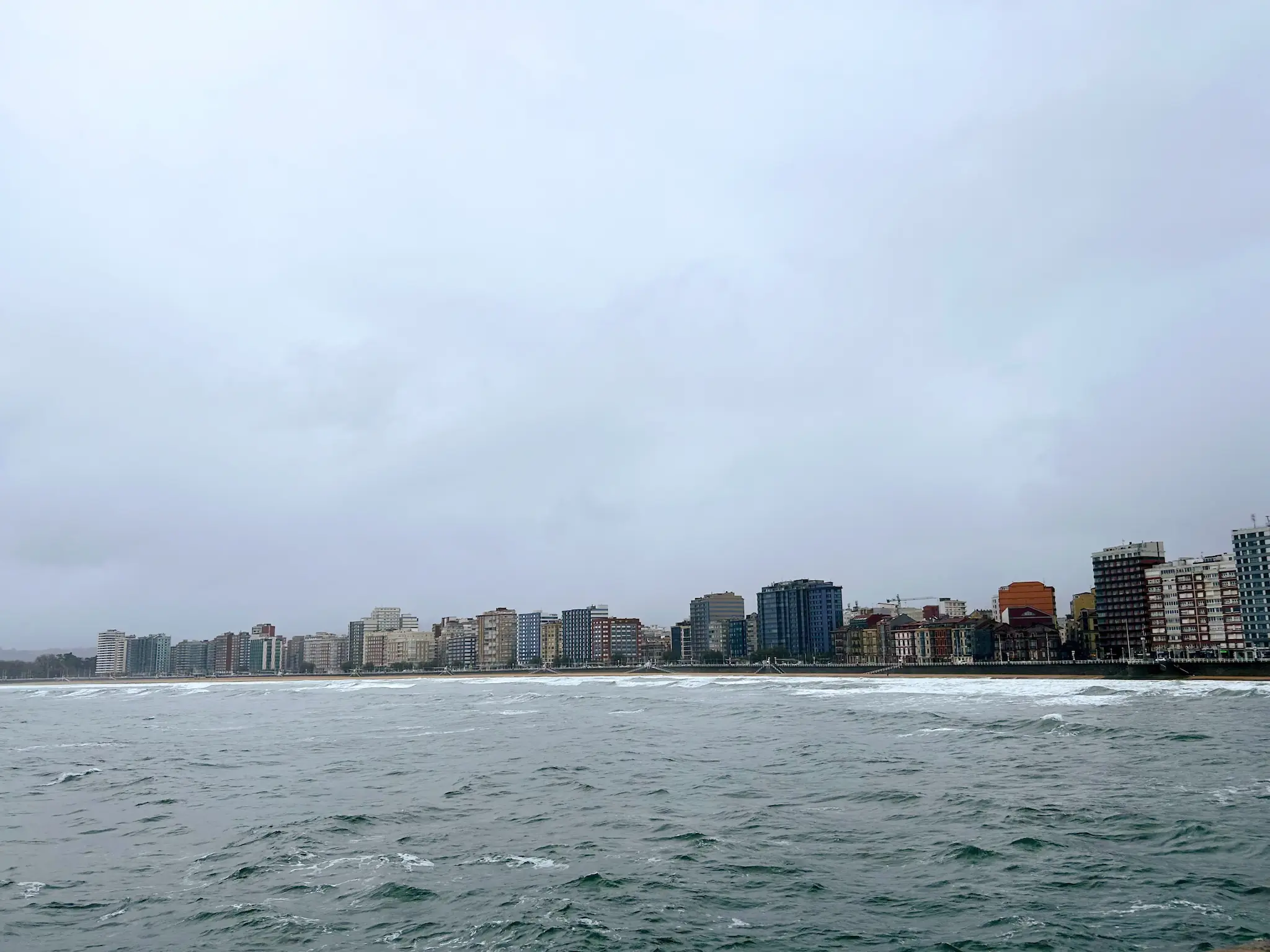 Panorámica aérea de la bahía y la Playa de San Lorenzo bordeada por el paseo marítimo de Gijón