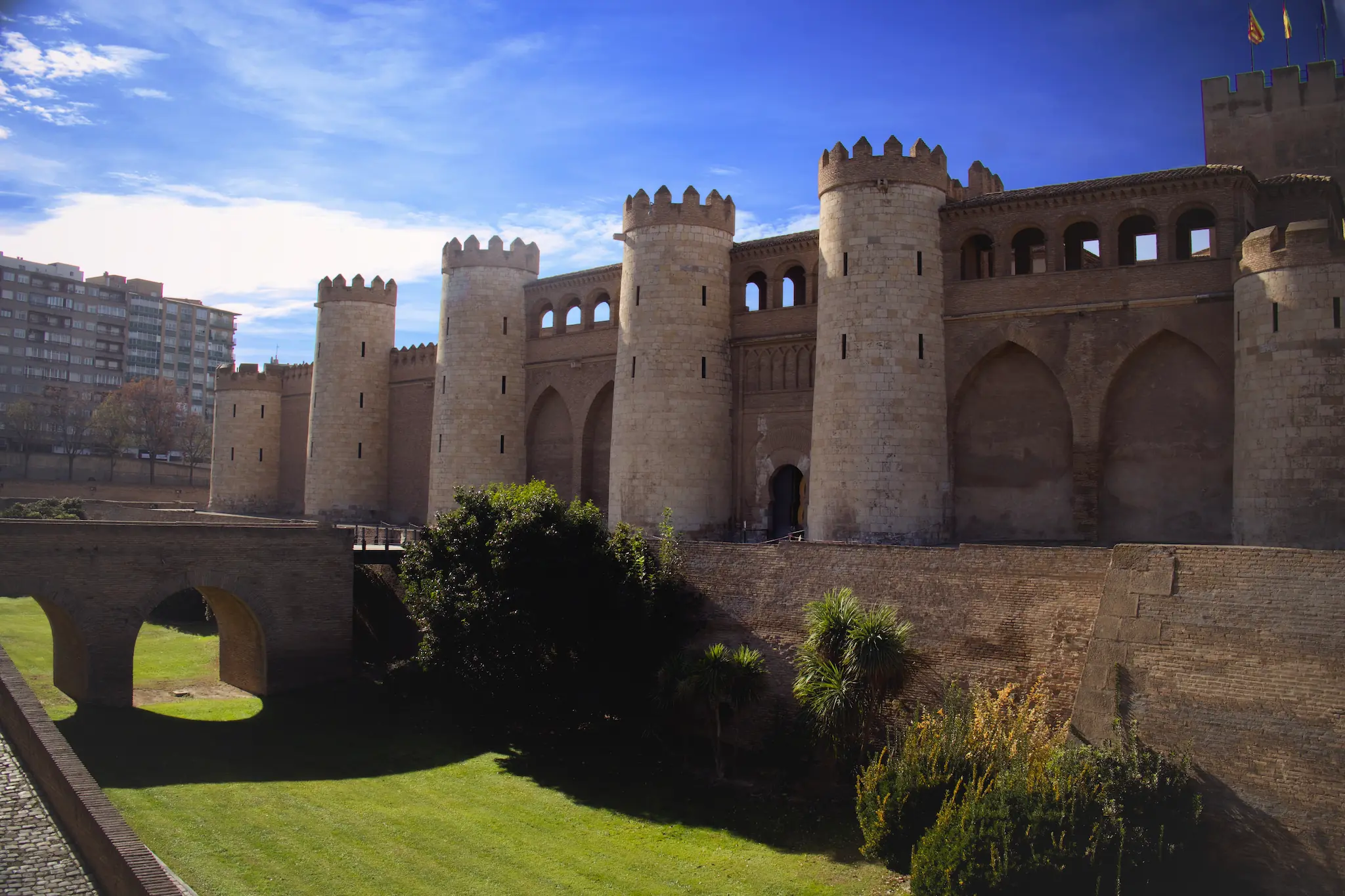 Imponentes murallas y torres del Palacio de la Aljafería bajo la luz del día